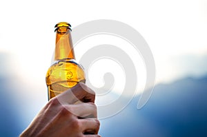 Bottle of beer. Natural background. Man handÂ´s keep a bottle of beer. Alcohol drink.