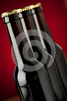 Bottle of beer on a stone table over red background