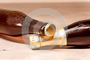 A bottle of blonde beer and a bottle of amber beer lying down