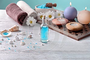 Bottle with blue liquid and blurred spa accessories on background