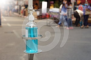 Bottle of blue sanitizer ethyl alcohol hand gel cleanser for Tourists on walking street