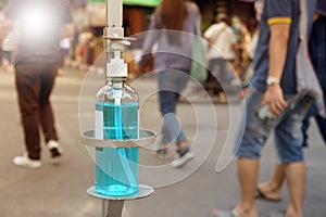 Bottle of blue sanitizer ethyl alcohol hand gel cleanser for Tourists on walking street