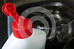 Bottle cap of dish soap on background of sink with dishes