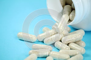 Bottle of capsules on blue background