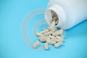 Bottle of capsules on blue background