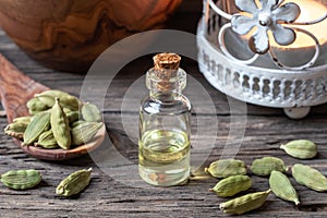 A bottle of cardamon essential oil with cardamon seeds