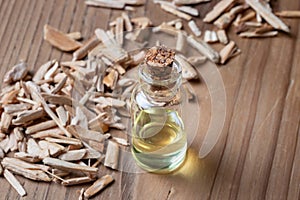 A bottle of cedar essential oil with cedar wood chips