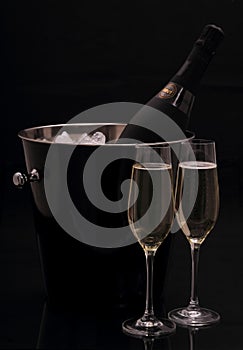 Bottle of champagne in bucket, two glasses