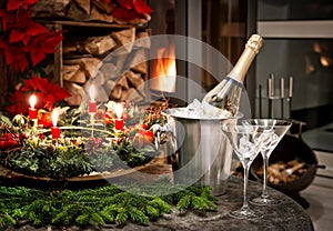 Bottle of champagne, glasses and fireplace