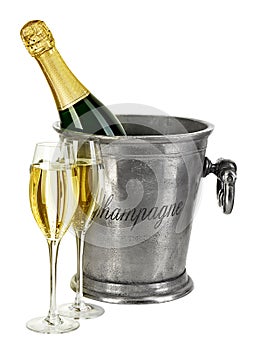 Bottle of champagne in ice bucket with stemware isolated