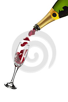 Bottle of champagne pouring red rose petals into glass