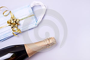 Bottle of Champagne Present Protective Face Mask on Blue Background New Year 2021 Celebration Concept Top view Flat lay Pandemic
