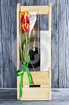 A bottle of champagne and Tulip flowers. the holiday is March 8, mother`s Day. Romantic setting.