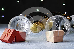 a bottle of champagne two glass glasses and gift boxes on a black background with backlight