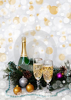 A bottle of champagne and two glasses on the background of fir branches