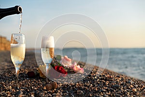 Bottle of champagne, two glasses on the beach