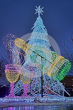 Bottle of Champagne with Two glasses and Christmas Tree in Twilight