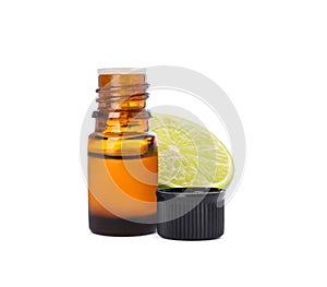 Bottle of citrus essential oil and cut fresh lime isolated