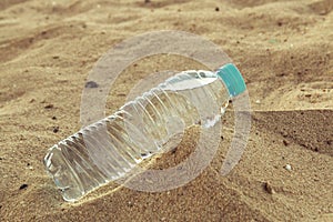 Bottle of clean drinking water in a dry desert, copy space.