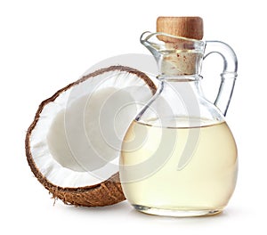 Bottle of coconut oil and half of coconut fruit on white background