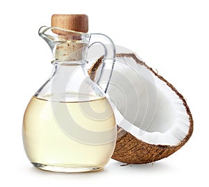 Bottle of coconut oil and half of coconut fruit on white background