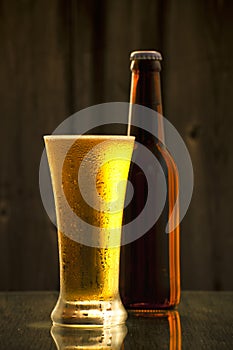 A bottle of cold draft beer with a glass