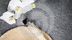 bottle of cologne, flowers on a gray background. Top view