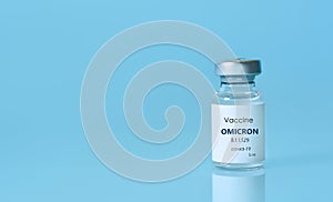 Bottle of Covid-19 vaccine to immunize from the Omicron Variant Coronavirus on blue background. The concept of medicine,