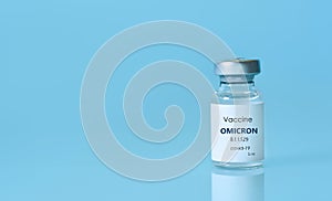 Bottle of Covid-19 vaccine to immunize from the Omicron Variant Coronavirus on blue background. The concept of medicine, photo