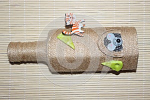 Bottle decorated with cord and figurines of cat and mouse