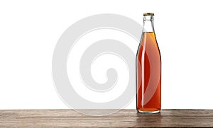 Bottle of delicious kvass on wooden table against white background