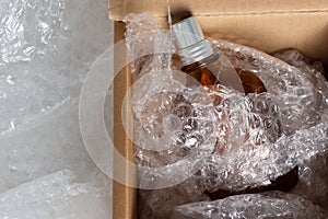 Bottle of eau de toilette or cologne in soft packaging in an open cardboard box