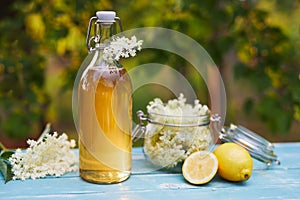 Bottle of elderflower syrup and elderberry flowers