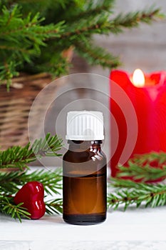 Bottle of essential oil and fir branches. Christmas or Valentine`s gift. Aromatherapy and spa concept.