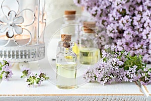 A bottle of essential oil with fresh blooming thyme