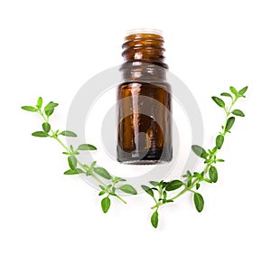 Bottle of essential oil with herbs thyme on white background