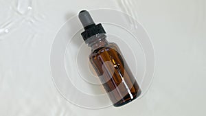 bottle of essential oil in water on a white background