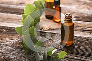 Bottle of eucalyptus essential oil on wooden background