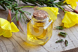 A bottle of evening primrose oil with evening primrose flowers a