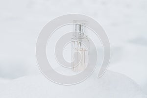 A bottle with a feminine fragrance on white snow in winter, the scent of coolness and freshness, background