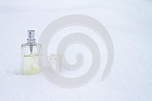 A bottle with a feminine fragrance on white snow in winter, the scent of coolness and freshness, background