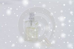 A bottle with a feminine fragrance on white snow in winter, the scent of coolness and freshness, background