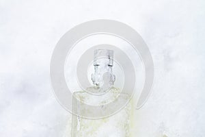 A bottle with a feminine fragrance on white snow in winter, the scent of coolness and freshness, background