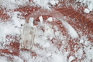 A bottle with a feminine fragrance on white snow in winter, the scent of coolness and freshness, background