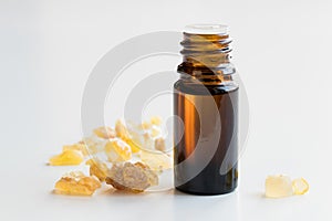 A bottle of frankincense essential oil with frankincense on whit