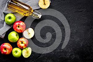 Bottle of fresh cider near autumn apples. Black background top view space for text