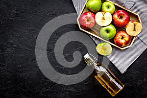 Bottle of fresh cider near autumn apples. Black background top view space for text