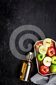 Bottle of fresh cider near autumn apples. Black background top view space for text