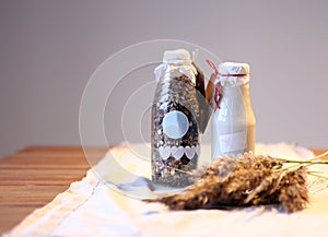 Bottle of fresh milk with Oat and whole wheat grains flake on wooden table. Bottle muesli with berries and bottle of