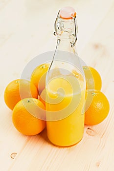 Bottle of freshly pressed orange juice with oranges